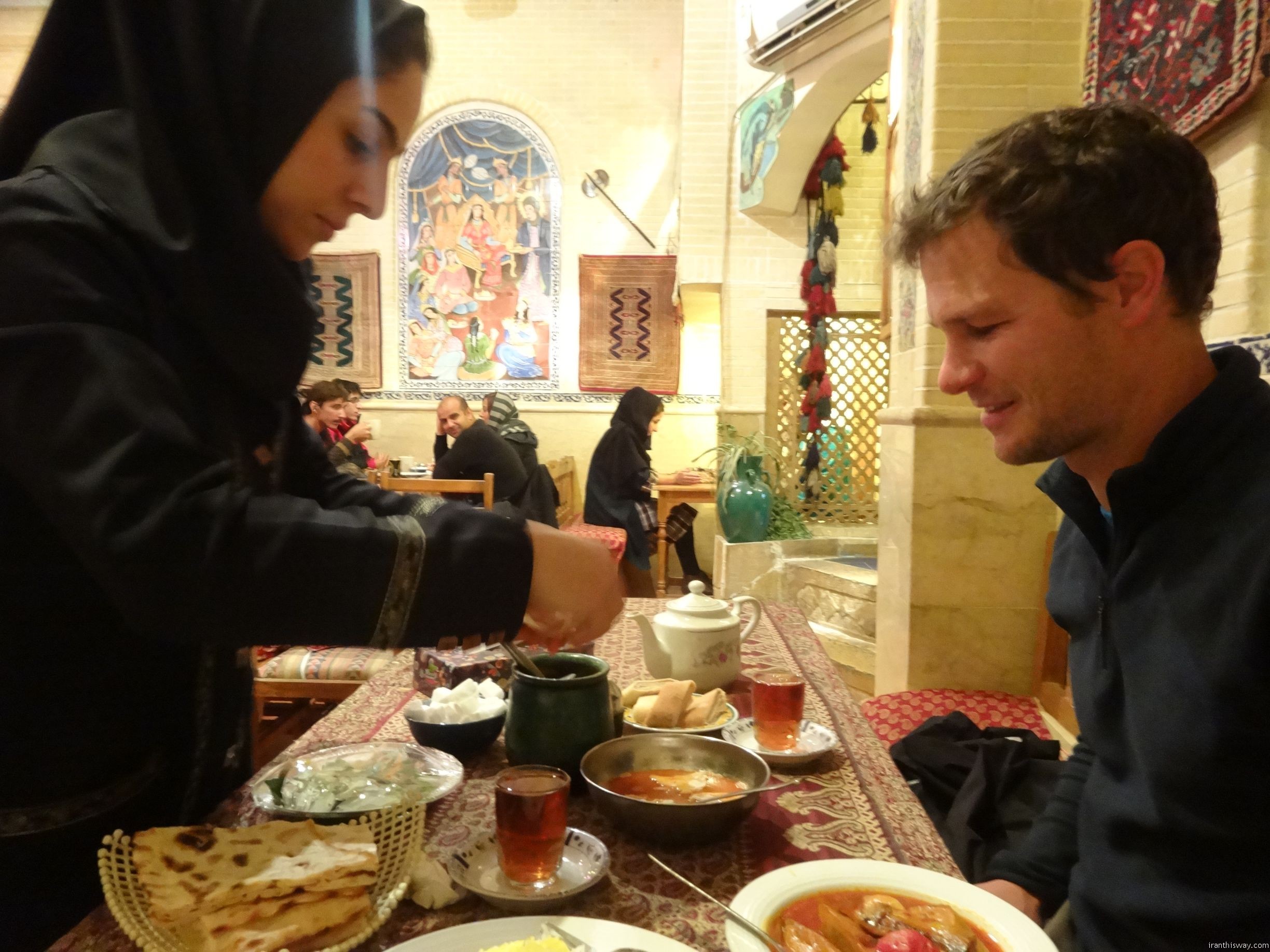 Jon getting a lesson in how to eat dizi